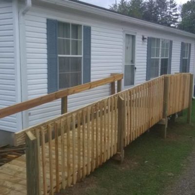 wooden ramp on the side of a white home